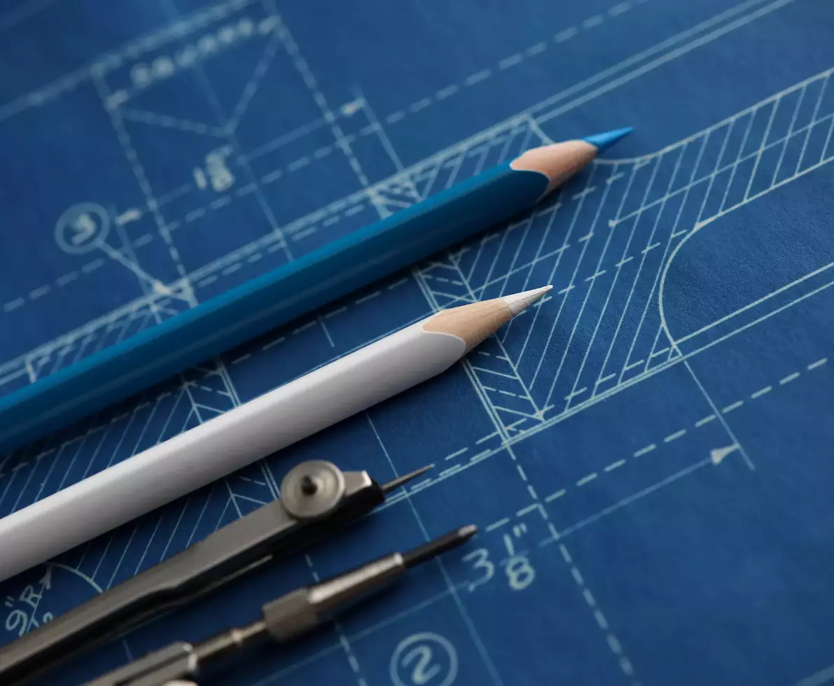 Drawing tools lying over blueprint paper close-up